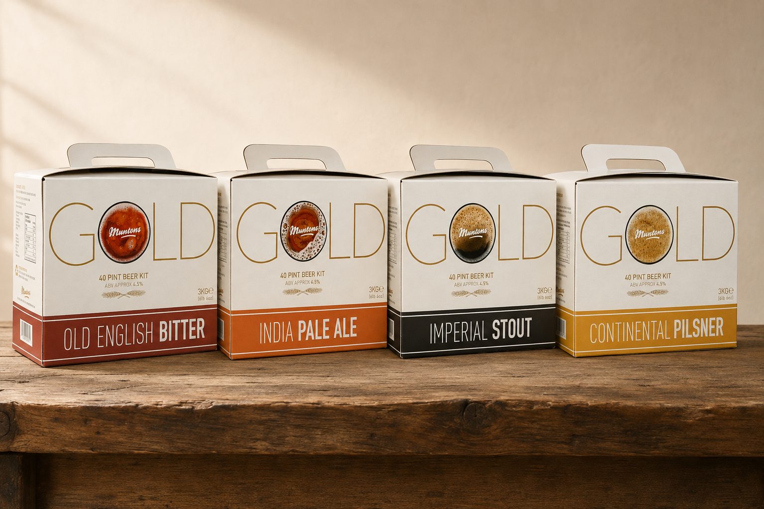 The four Muntons Gold carry-handle kit boxes on a wooden bench — Old English Bitter, India Pale Ale, Imperial Stout and Continental Pilsner — each with GOLD in thin gold lettering, the O a glass of the beer with the Muntons script across it.